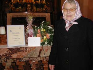 Fr. Groll mit Urkunde und Geschenk vom Kirchenchor